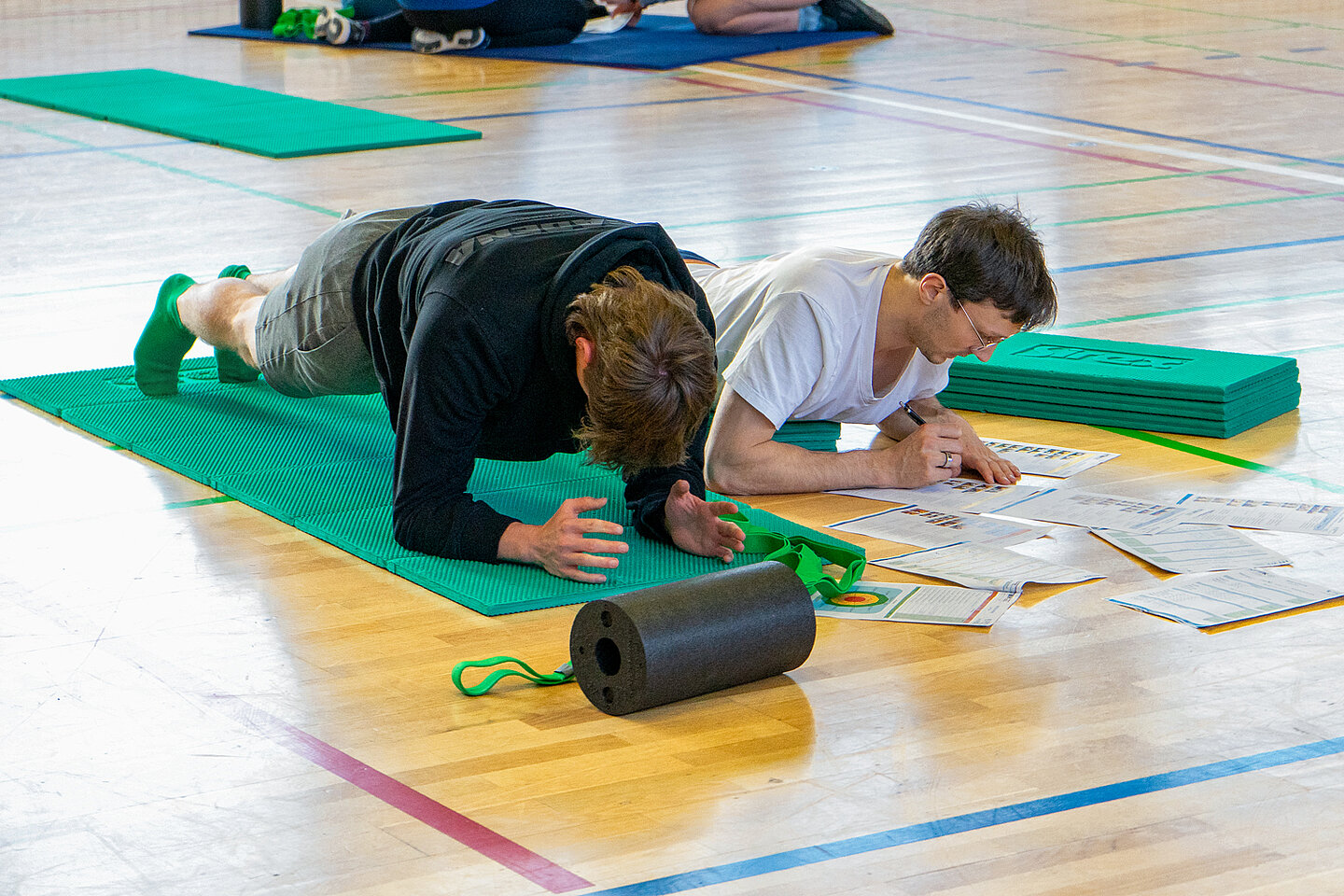 HOZ Rückenscreening zwei Männer üben auf einer Sportmatte