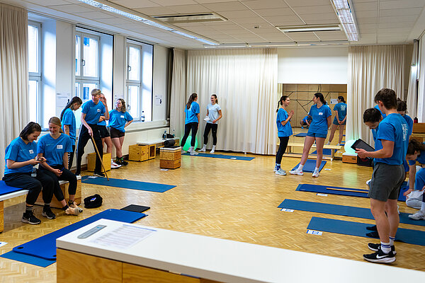 Rückenscreening HOZ Gruppe von Menschen in Sportkleidung in Raum mit Matten