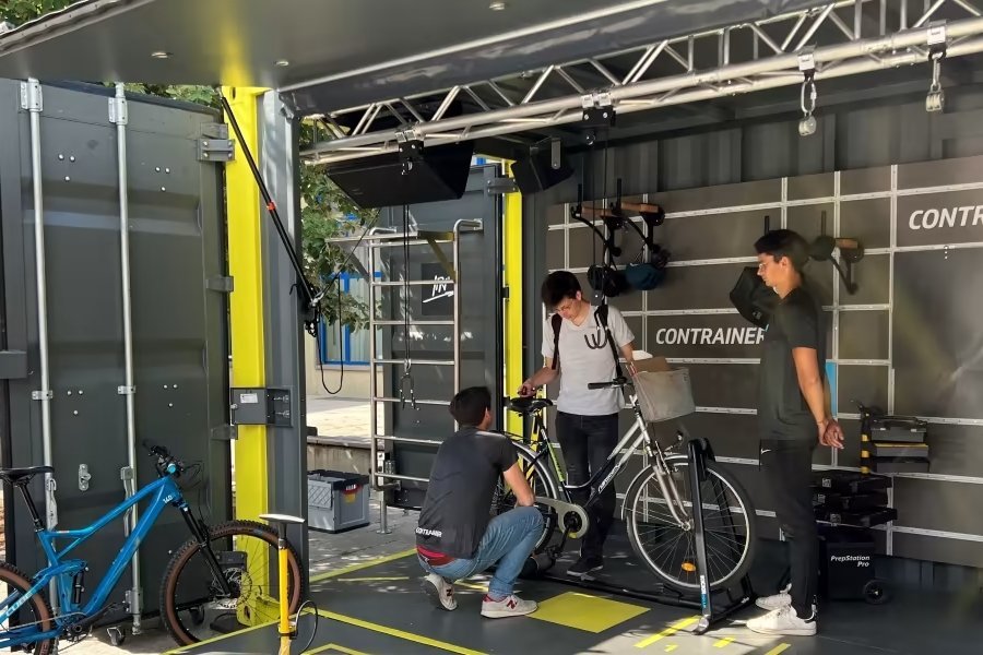 Ein großer Container, in dem das Fahrrad einer Person begutachtet und passend angepasst wird.